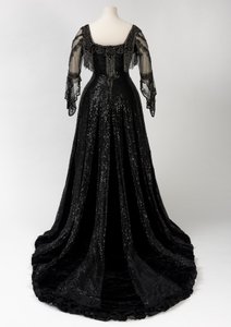 Sort kveldskjole i full lengde båret av dronning Alexandra, med dekorasjon av perler og paljetter og inkorporert dronning Alexandras signaturteip i svart silke og gull, laget av Barolet fra Knightsbridge, London 1908-1910 (silke og fløyel) av Unbekannt