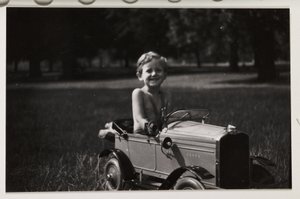 Gutt kjører en leketøypedalbil, ca 1930 av Unbekannt