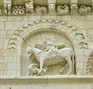Romansk kunst: detalj av fasaden som viser Hugues de Surgeres og Geoffroy de Vendome eller keiser Konstantin I den store hvis fot av hesten ville tråkke Heresie og Kristus triumferende over ondskap og død, Notre Dame (Notre-Dame) de Surgeres (17700) av Unbekannt