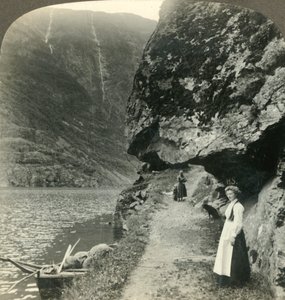 Der veien kryper under de utstikkende klippene ved vannet i Nerofjorden, Norge, c1905. av Unbekannt