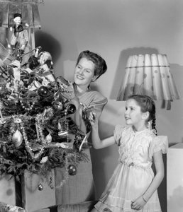 Kvinne og jente pynter et juletre, ca 1948 av Unbekannt