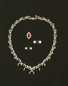 Art Deco rulle- og bladdesignkjede; rubin og diamant baguette klynge ring; safir og diamant tre stein ring; smaragd og diamant tresteinsring
