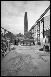 En generell oversikt over Elswick Shot Tower, revet 1968-69, brukt til å lage blyhagler, med en hage med paletter i forgrunnen, ca. 1955-69 (s/hv-foto) av Unbekannter Künstler