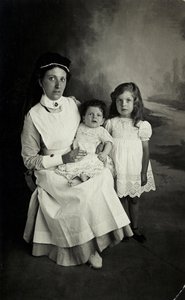 En "sykepleier" som poserer med barn på 1920-tallet. av William M. Timlin