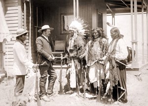 Tre Cheyenne kledd i seremoniell kostyme og iført våpen hilser en hvit akkompagnert av en tolk. sd. slutten av 1800-tallet av Unknown artist