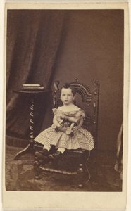 [Uidentifisert liten jente som holder en trehest, sittende] av Unknown artist