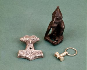 Amuletter av vikingguder: i forgrunnen to små sølvhammere som symboliserer guden Thor. Statuetten representerer Freyr, fruktbarhetsguden. Historisk museum i Stockholm, Sverige.