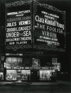 1554 Broadway på 46th Street, I. Miller Shoes; James Drug Store, og store markiser for filmer lyser opp ovenfor. av William Davis Hassler