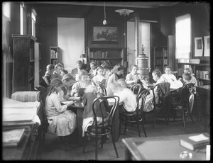 Barn som leser på lesesalen til en uidentifisert filial av Queens Borough Public Library, ca. 1910 av William Davis Hassler