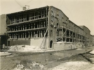 Byggeplass, to menn som står på den åpne siden av lagerbygningen; Robbins und Ripley Engineers and Contractors, 23. mars 1916 av William Davis Hassler