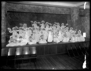 Gruppe med små jenter poserte på en liten scene med fans, sannsynligvis det romersk-katolske orphan asylum, Kingsbridge, Bronx, ca. 1911 av William Davis Hassler