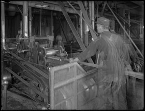 Arbeider som mater trelast inn i en høvel, Oneida, New York, 3. april 1916 av William Davis Hassler