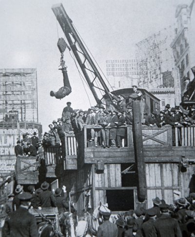 Houdini rømmer fra en tvangstrøye mens han ble hengt opp i en kran i New York City (s/hvitt-bilde) av American Photographer