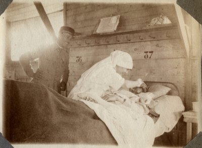 Første verdenskrig 1914-1918: sykepleier i bluse barberer en soldat (franske krigssår ligger i en seng), i Couville, Manche, Basse-Normandie (Nedre-Normandie), Frankrike. Anonymt fotografi juli 1917. Privat samling, Stella. av Anonymous Anonymous