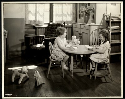 To blinde synshemmede jenter spiser ved et lite bord med dukke hos New York Association for the Blind, 111 East 59th Street, New York, 1933 (sølv gelatintrykk) av Byron Company