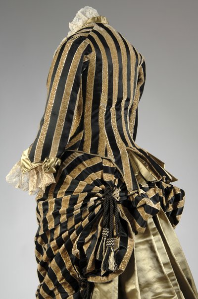 Aftenkjole, ca. 1884 (skrå delvis rygg). Silkesateng og kuttet fløyel, blonder, silketråddusker og frynser. Charles Frederick Worth, Frankrike. av Charles Frederick Worth