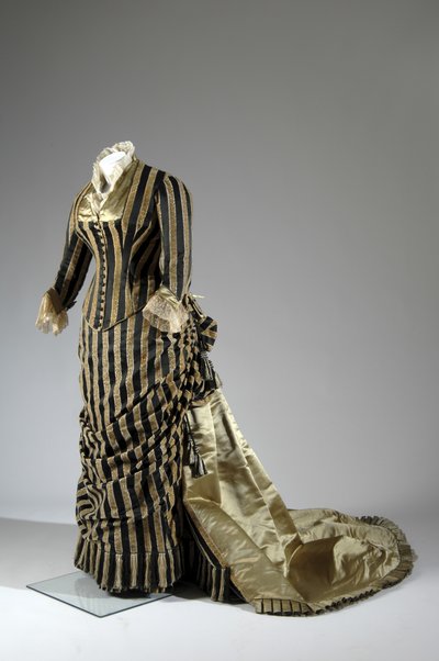 Aftenkjole, ca. 1884 (skrå utsikt fra siden). Silke sateng og kuttet fløyel, blonder, silketråd dusker og frynser. Charles Frederick Worth, Frankrike. av Charles Frederick Worth