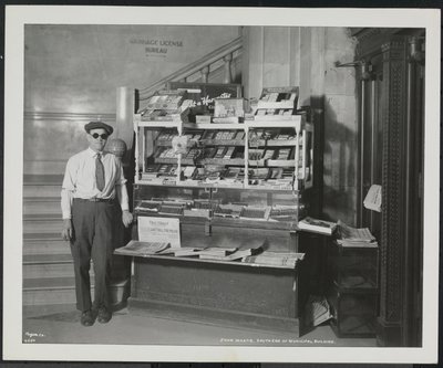 Blind nyhetsforhandler, John Martie, på standen hans i sørenden av kommunalbygningen, New York av Company Byron