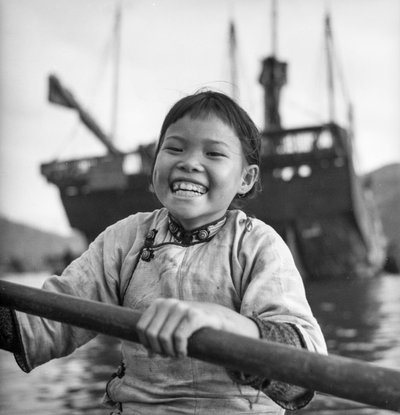 Et portrett av en ung jente i en sampan i Aberdeen havn, Hong Kong. av David Watkin Waters