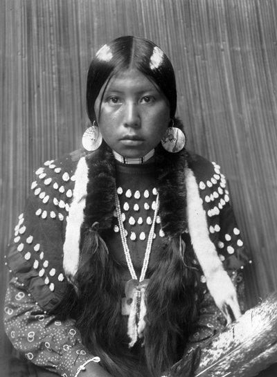 Kalispel indisk kvinne, hvite striper malt på håret, øredobber med skjell, iført teppekjole dekorert med elgens tenner, ca. 1910, foto Edward S. Curtis av Edward Sheriff Curtis