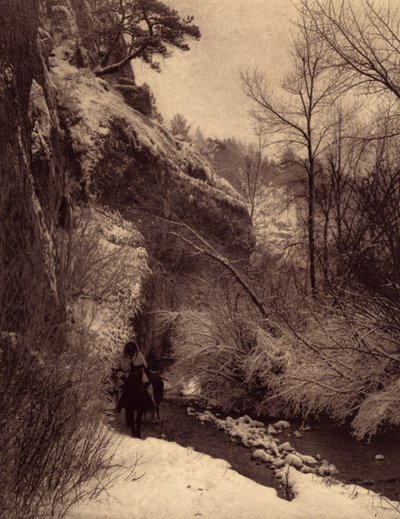 Passerer klippen, vinterscenen. Apsaroke-indianere som rir langs en klippe i snøen på Pryor River, Montana. Foto hentet fra bind 4 av leksikonet utgitt av Edward S. Curtis (1868-1952) om indianerne i Nord-Amerika, med et forord av Theo av Edward Sheriff Curtis