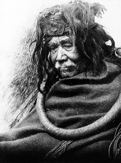 Hamatsa, Nakoaktok c. 1910 Halvlangt portrett av Nakoaktok-mannen, vendt mot venstre, iført seremoniell løkke av sedertrot. av Edward Sheriff Curtis