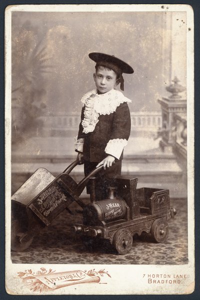 Gutt med leketog og trillebår av English Photographer