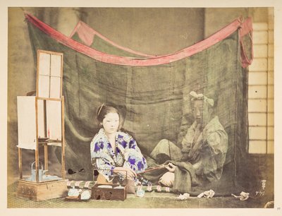 japansk par på fritiden, Studio-tableau av en ung japansk kvinne, sittende med tekokende hindring rundt seg, og gir en pipe til en mannsfigur som sitter bak henne, skjermet av et linmyggnett,   Fotograf: Ukjent  Lucas samling: av English Photographer