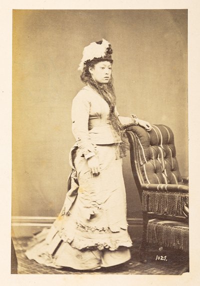 Japansk kvinne i europeisk kjole, Stående studioportrett i full lengde av en ung japansk kvinne i vestlig kjole og hatt,  Fotograf: Ukjent  Lucas Collection: Fotografisk oversikt over verdensturneen til Charles James og Morton P, Lucas av English Photographer
