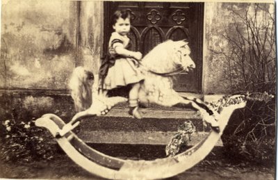 Liten jente på en stor gyngehest i en hage, 1860-tallet (albumintrykk) av English Photographer