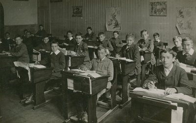 Mannlige elever som sitter bak pultene sine under en leksjon på skolen av English Photographer