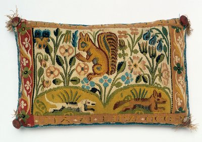 Et nålepute-teppepanel med et ekorn og motto "god vilje er alt" av English School
