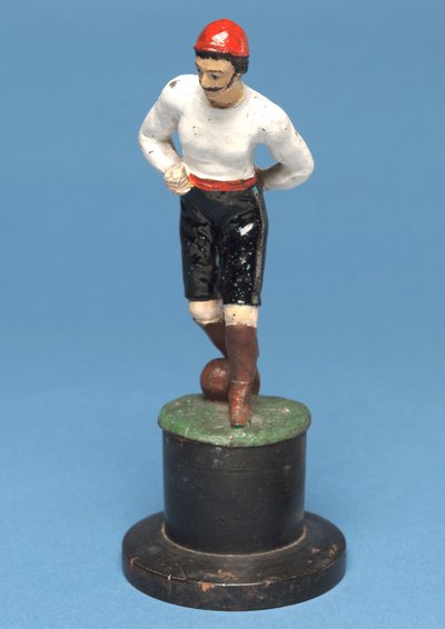 Fotballspiller med ballen ved føttene (håndmalt metall) av English School