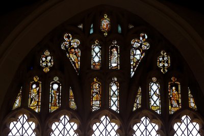 Window Ew som viser tracery-lysene med Gud, Treenigheten, St. Peter. St Paul, St Catherine og Gabriel: og en fugl av English School