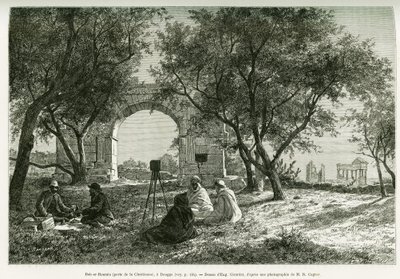 Bab-er-Roumia (Bab er Roumia), porten til den kristne kvinnen, romerske ruiner i Dougga, piknik for reisende og deres guider, rundt et kamera. Gravering av Eugene Girardet, for å illustrere historien Voyage en Tunisie, av R.Cagnat og H.Saladin, anklager om av Eugene Alexis Girardet