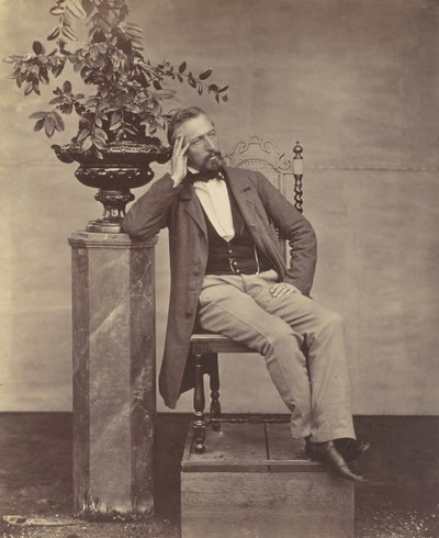 [Mathias Höusermann sittende med albue på pidestall og holder en vase med blomster], 1850-60-tallet. av Franz Antoine