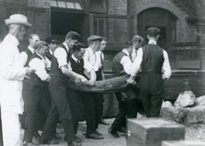 Et team av menn bærer en Alligator overvåket av Sir Peter Chalmers Mitchell, London Zoo, 1924 av Frederick William Bond