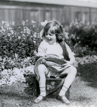 En ung jente Betty som holder en Eastern Indigo Snake mens hun sitter på en skinnkoffert, London Zoo, 1924 av Frederick William Bond