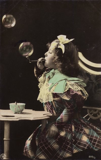 En liten jente som blåser bobler fra et rør (tonet bilde) av French Photographer