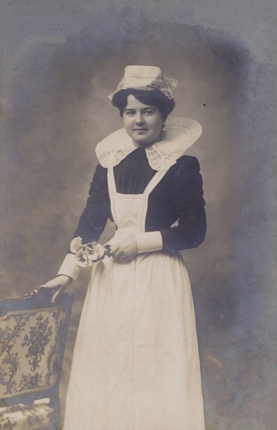Ung jente, hushjelp (?), holder en liten bunt blomster av French Photographer