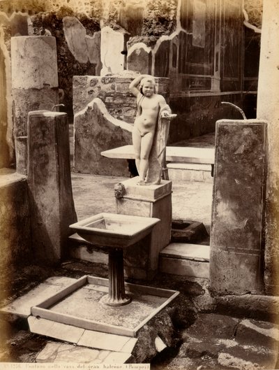 En fontene sammensatt av en skulptur av en ung gutt naken. Fontenen er i House of Balcone pensil, i Pompei av Giorgio Sommer