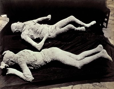 To avstøpninger av menneskelige figurer fra utgravningene i Pompeii. Utstillingene ble plassert på svart tøy for å fotografere dem av Giorgio Sommer