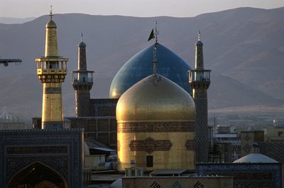 Helgullkuppelen og minareten til helligdommen til Imam Reza, den åttende sjia-imamen, med Timurid Gowhar Shad-moskeen bak av Islamic School