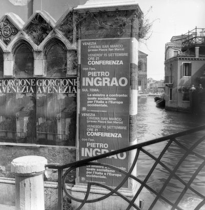 Utsikt over en kanal i Venezia med plakater som reklamerer for en Giorgione-utstilling og et politisk manifest i forgrunnen av Italian Photographer