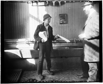 Portrett av en avisgutt som leverer et papir til en mann i det som ser ut til å være et toalett på Duane Street Lodging House av Jacob August Riis