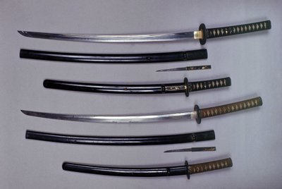 Topp: en katana, japansk sverd og slire, wakizashi, japansk kort sverd i slire, liten Kokatawa-dolk oppbevart i samme slire. alle tre er fra 1700-tallet. de nederste er fra 1600-tallet. av Japanese School