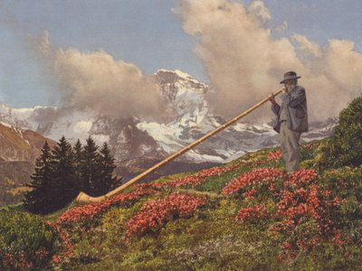 Sveits: An Alphorn Blower, Jungfrau i bakgrunnen (fargebilde) av Jean Gaberell