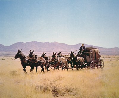 Western Stagecoach trukket av et lag med seks muldyr (bilde) av Walter Charles Mills