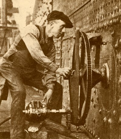 'En pneumatisk riveter som skjærer koøyer på siden av en liner', c1930. av John Brown and Company