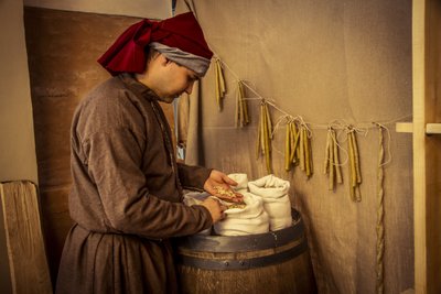 Historisk gjeninnføring: Stearinlys og sekker med hvete, rug og bygg i apoteket i Diotaiuti, Imola, Italia, midten av 1300-tallet (bilde) av Unbekannt Unbekannt